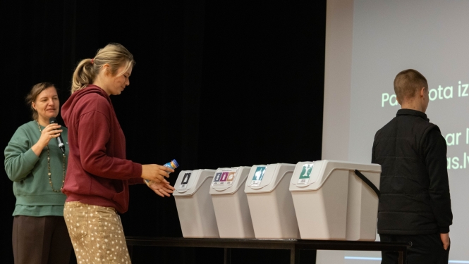Meitene met atkritumu urnā atkritumus
