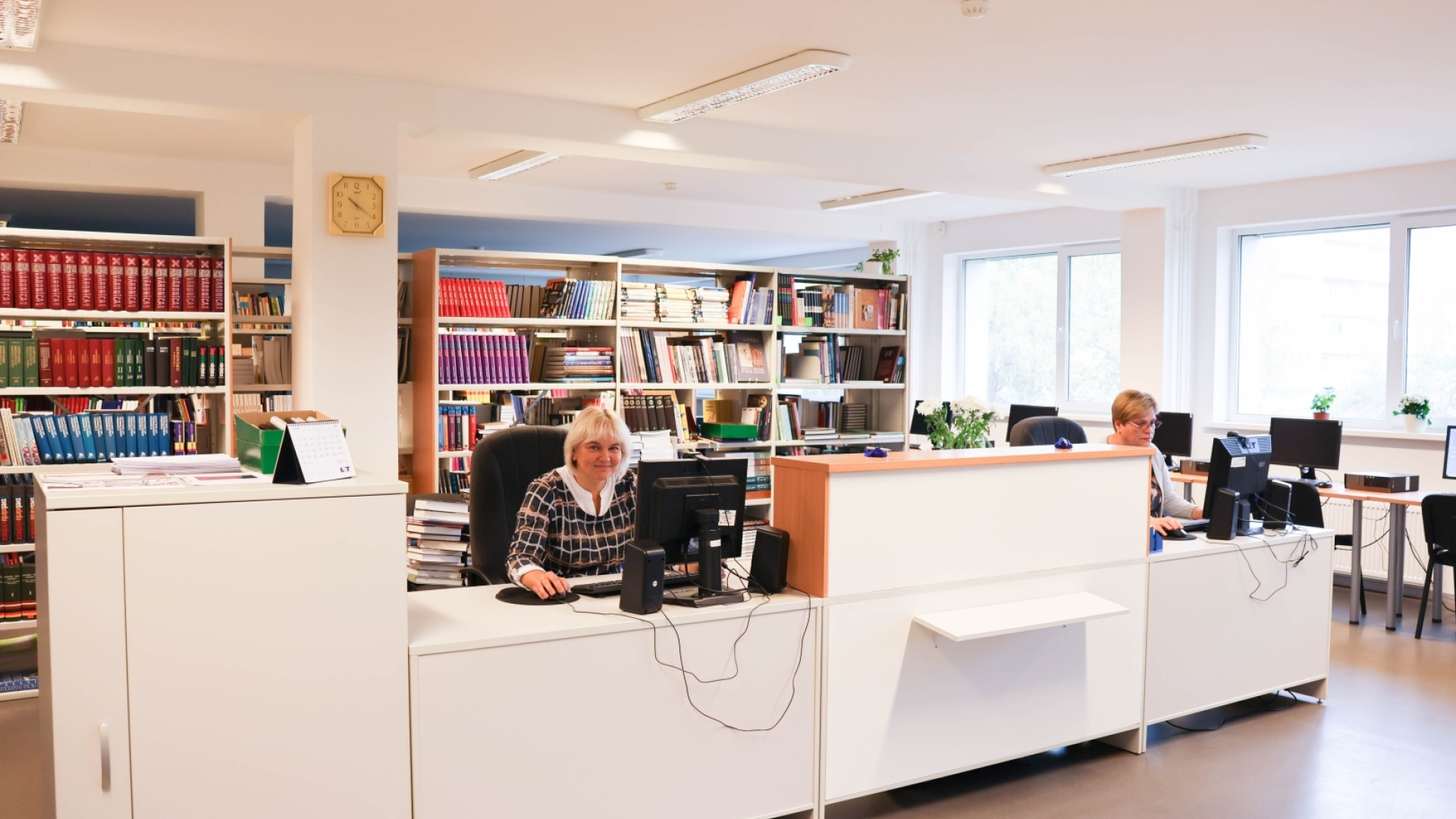 Bibliotekāre sēž pie galda