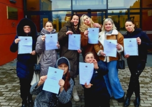 Kopbilde ar dalībniekiem — ar diplomiem skolas priekšā